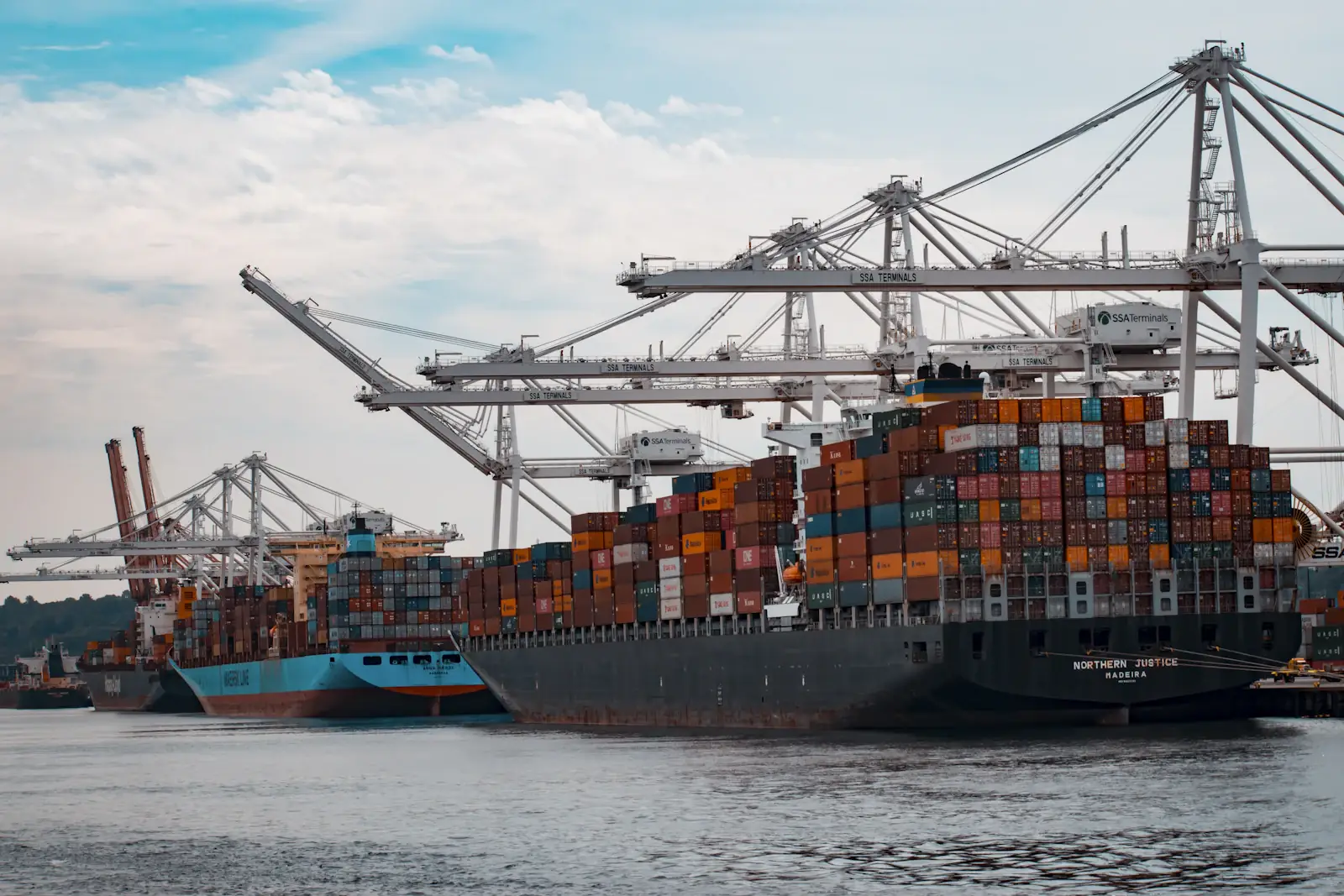 Container ship being loaded by cranes at a port